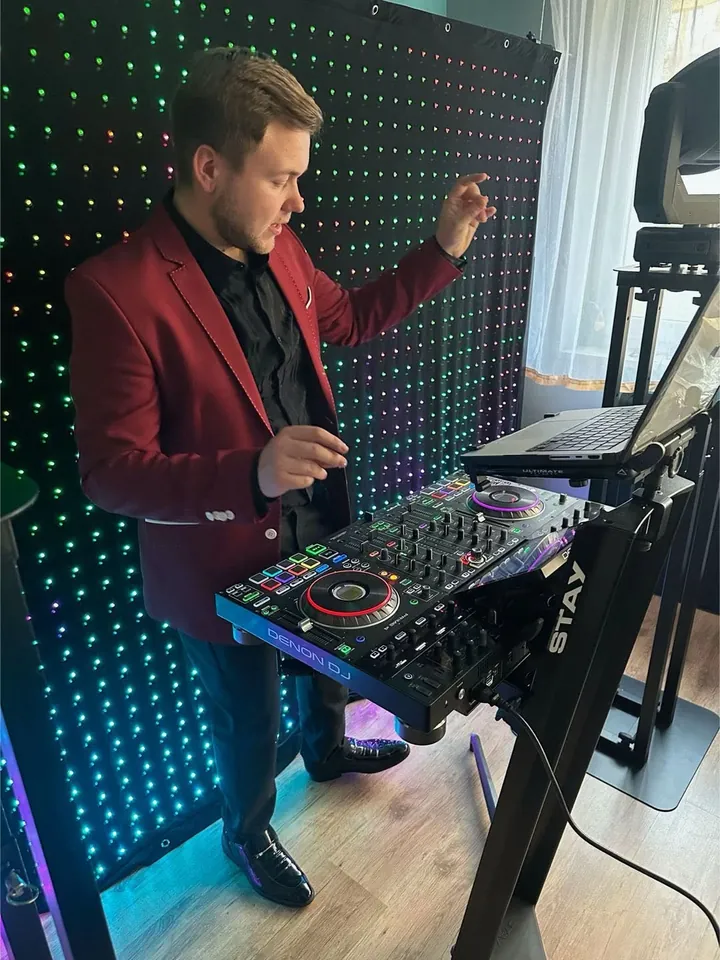 Maxis DJ przy konsolecie na tle kurtyny LED